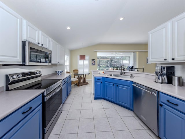 kitchen featuring light tile patterned floors, appliances with stainless steel finishes, blue cabinets, and a sink