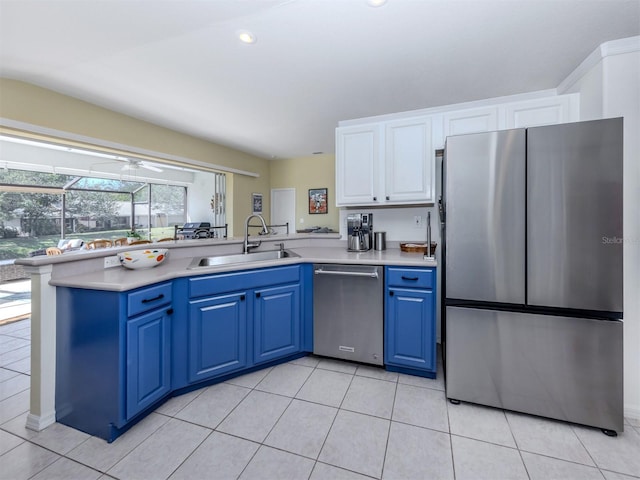 kitchen featuring blue cabinetry, a sink, light countertops, white cabinets, and appliances with stainless steel finishes