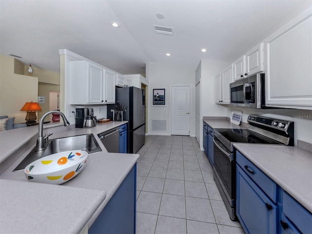 kitchen with blue cabinetry, a sink, light countertops, appliances with stainless steel finishes, and white cabinetry