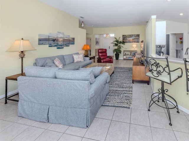 living area featuring light tile patterned floors, visible vents, lofted ceiling, and baseboards