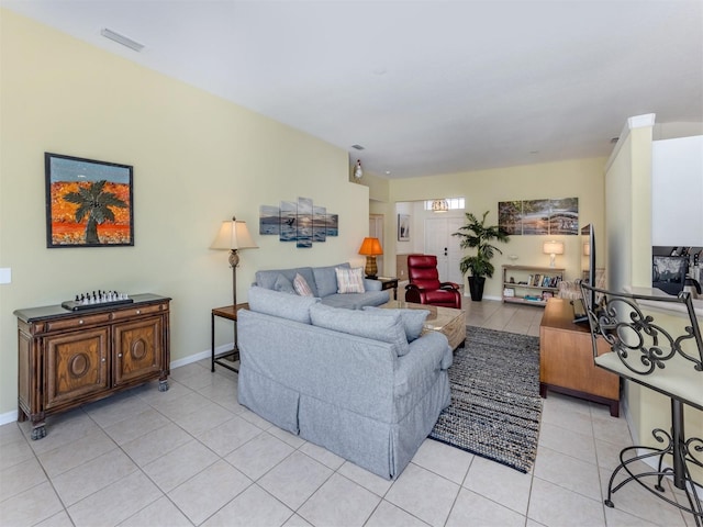 living room featuring light tile patterned floors, visible vents, and baseboards