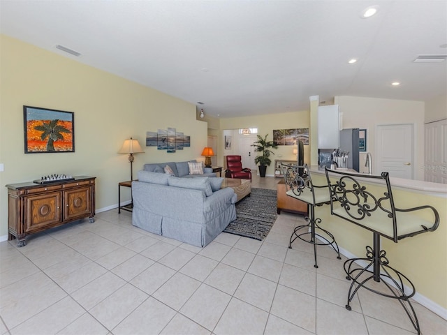 living area with light tile patterned floors, visible vents, baseboards, and recessed lighting