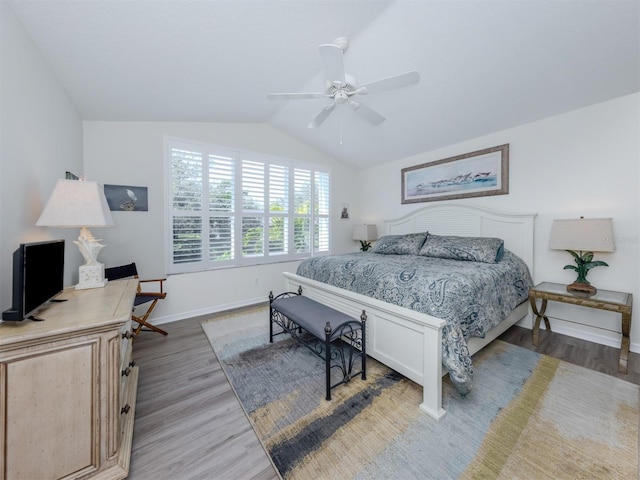 bedroom with ceiling fan, baseboards, light wood-type flooring, and lofted ceiling