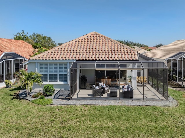 back of house with an outdoor living space, a yard, a patio, and a tiled roof