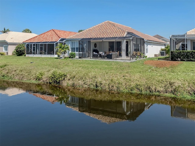 back of house featuring a lanai, a tiled roof, a patio area, and a water view