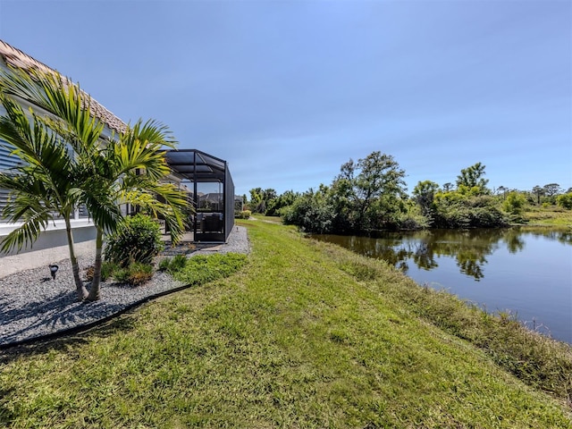 view of yard with glass enclosure and a water view