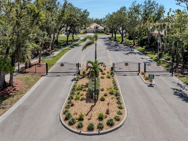 view of street featuring curbs, a gated entry, and a gate