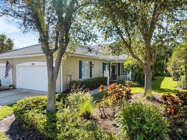 ranch-style home with stucco siding, concrete driveway, a garage, and a front yard