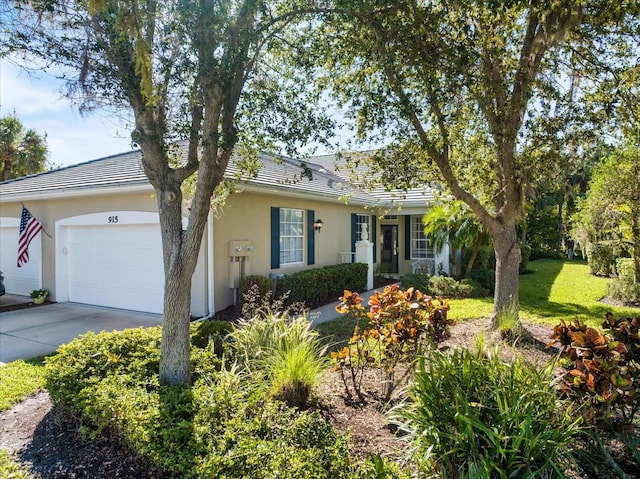 single story home with concrete driveway, a front lawn, a garage, and stucco siding