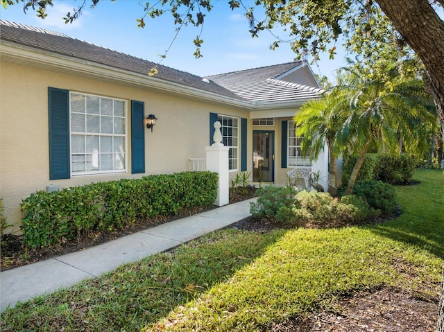 view of front of home with stucco siding and a front yard