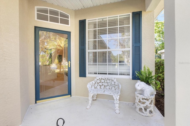 entrance to property featuring stucco siding