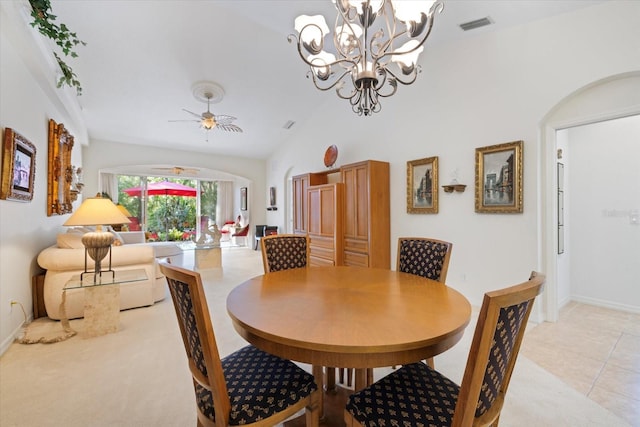 dining space featuring light tile patterned floors, visible vents, arched walkways, light carpet, and ceiling fan with notable chandelier