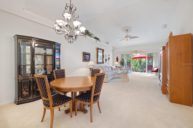 dining space with visible vents, light carpet, lofted ceiling, and ceiling fan with notable chandelier