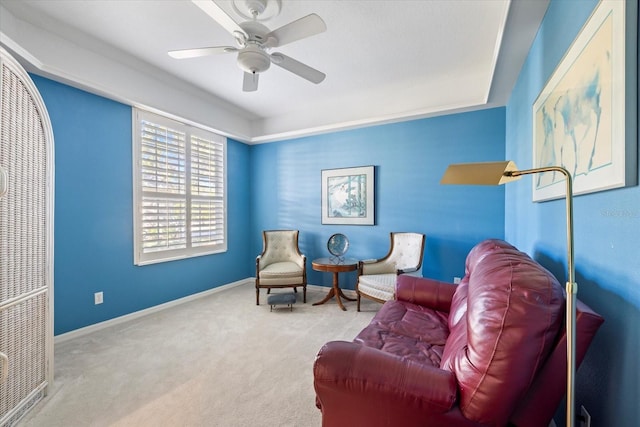 sitting room with a ceiling fan, baseboards, and carpet floors