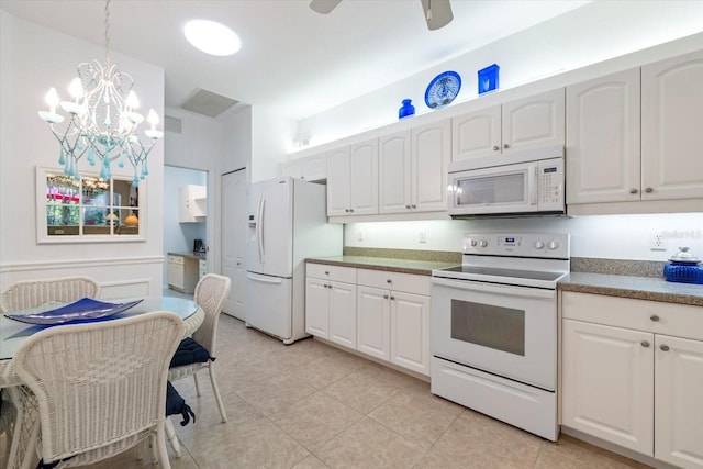 kitchen with white appliances, white cabinets, and pendant lighting