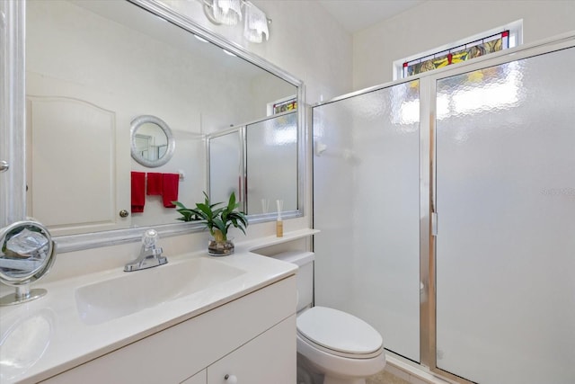 bathroom featuring toilet, a stall shower, and vanity