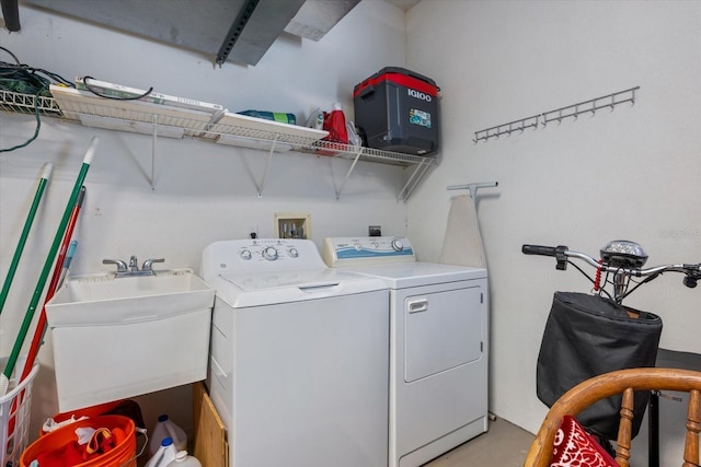 washroom featuring washer and dryer, laundry area, and a sink