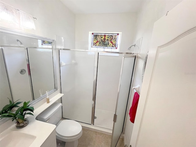 bathroom with toilet, a stall shower, and vanity