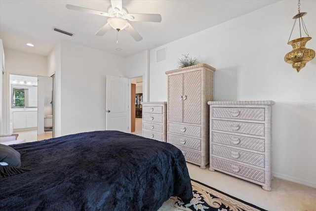 bedroom featuring visible vents, light colored carpet, connected bathroom, and a ceiling fan