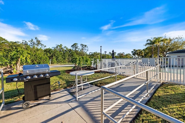 view of patio with area for grilling and fence