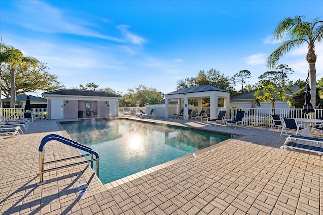 community pool with a gazebo, a patio, and fence
