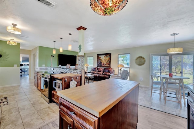 kitchen featuring pendant lighting, stainless steel electric range oven, visible vents, and light countertops