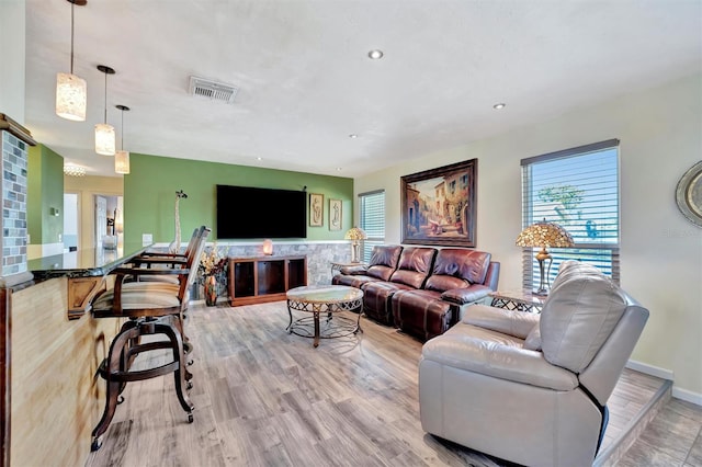 living area featuring baseboards, recessed lighting, visible vents, and light wood-type flooring