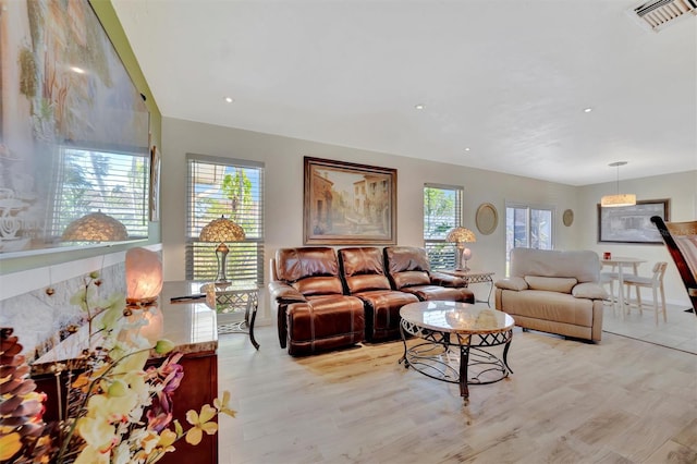 living room with recessed lighting, visible vents, and light wood finished floors