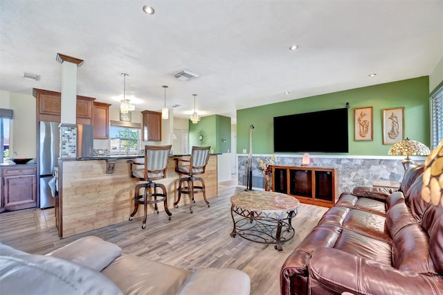 living room with light wood-style flooring, recessed lighting, and visible vents