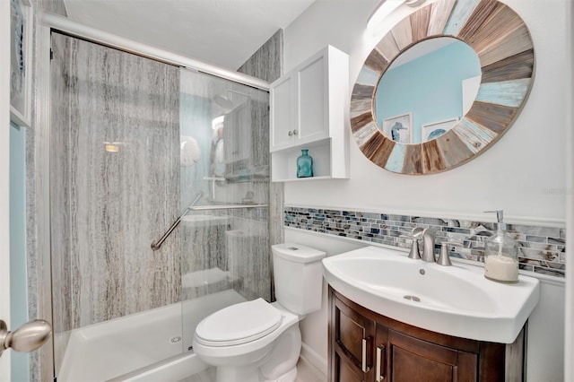 bathroom with decorative backsplash, a stall shower, toilet, and vanity