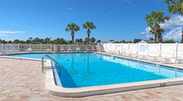 pool with a patio and fence