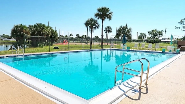 pool featuring a lawn and fence