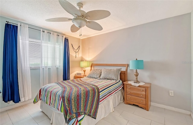 tiled bedroom featuring baseboards, a textured ceiling, and ceiling fan