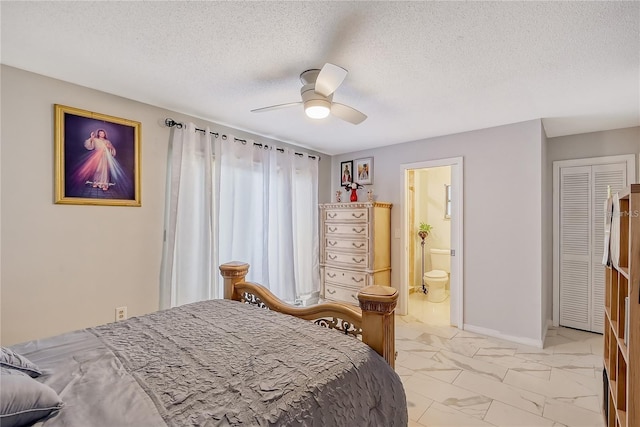 bedroom featuring marble finish floor, ensuite bathroom, a ceiling fan, a textured ceiling, and baseboards