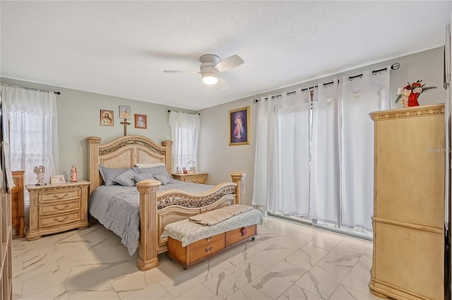 bedroom with marble finish floor, a textured ceiling, and a ceiling fan