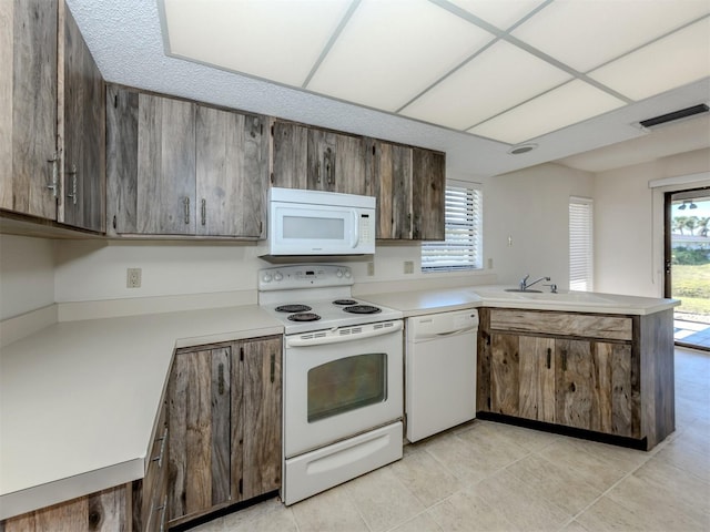 1602 Jim Jim Ct, Venice, FL 34293 - kitchen with white appliances, a peninsula, light countertops, and healthy amount of natural light