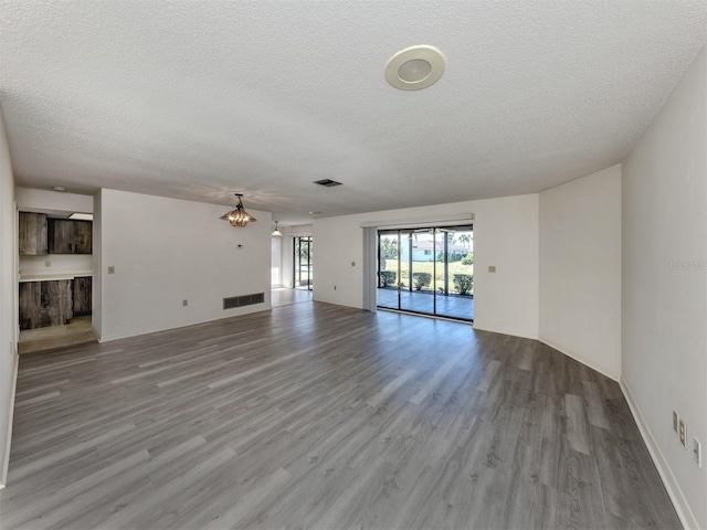 1602 Jim Jim Ct, Venice, FL 34293 - unfurnished living room with a textured ceiling, wood finished floors, and a chandelier