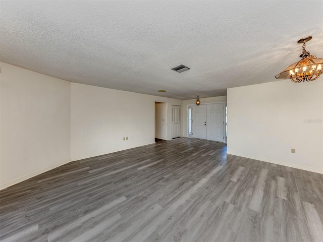 1602 Jim Jim Ct, Venice, FL 34293 - unfurnished room with dark wood-style floors, a chandelier, and a textured ceiling