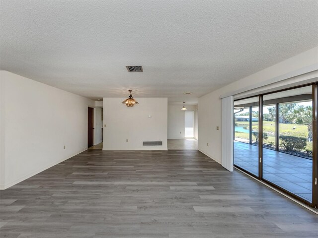 1602 Jim Jim Ct, Venice, FL 34293 - unfurnished living room featuring wood finished floors, a chandelier, and a textured ceiling