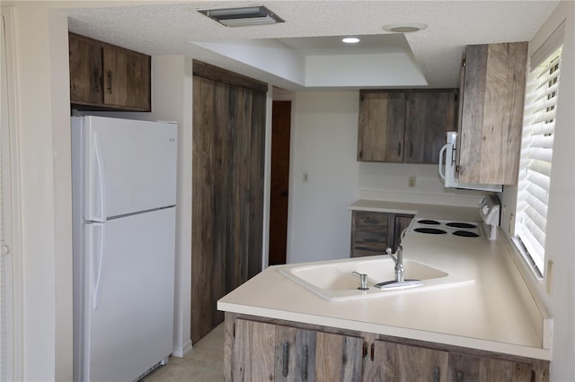 1602 Jim Jim Ct, Venice, FL 34293 - kitchen with white appliances, a peninsula, a textured ceiling, light countertops, and a raised ceiling