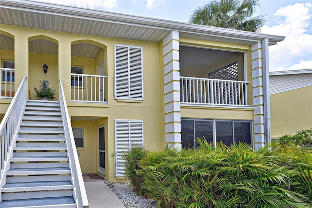 exterior space with stucco siding and stairway