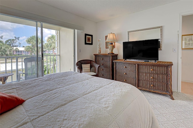 carpeted bedroom with access to exterior, multiple windows, and a textured ceiling