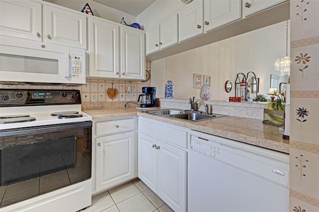 kitchen featuring light tile patterned floors, white appliances, white cabinetry, and a sink