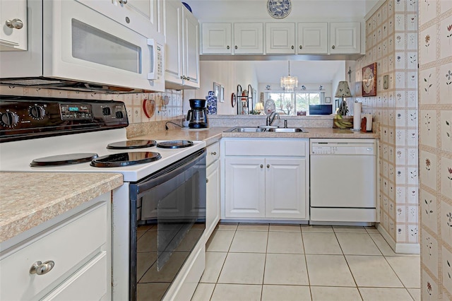 kitchen featuring light countertops, light tile patterned floors, white cabinets, white appliances, and a sink