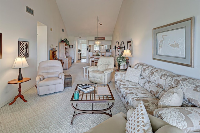 living area featuring visible vents, carpet floors, high vaulted ceiling, and baseboards