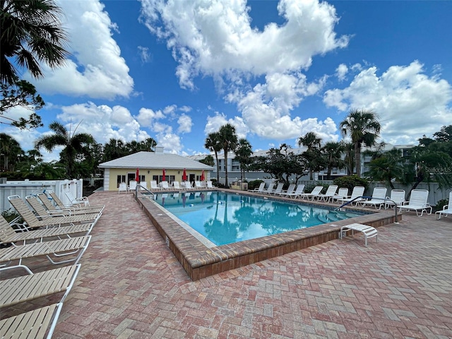 pool with a patio and fence