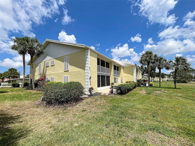 view of side of home featuring stucco siding and a lawn