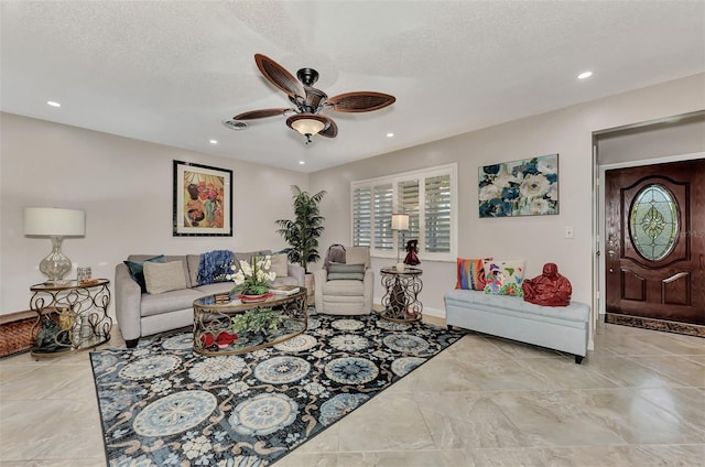 living room with recessed lighting, a ceiling fan, and a textured ceiling