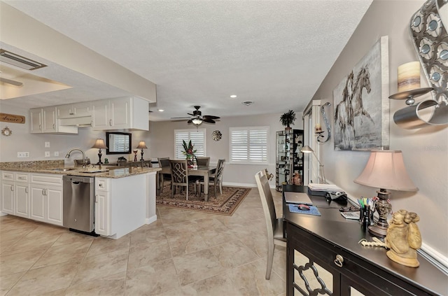 kitchen featuring stainless steel dishwasher, white cabinets, a ceiling fan, and a sink