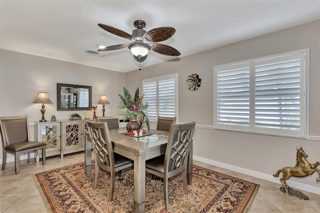 dining area featuring light tile patterned flooring, visible vents, baseboards, and ceiling fan